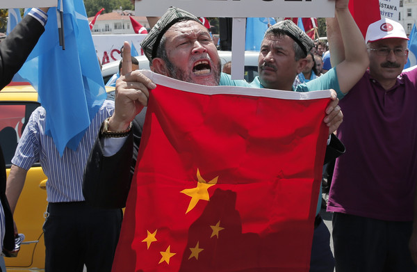 ▲一名維吾爾族人在土耳其的一場示威活動上，舉著五星旗抗議中國當局打壓。（圖／達志影像／美聯社）