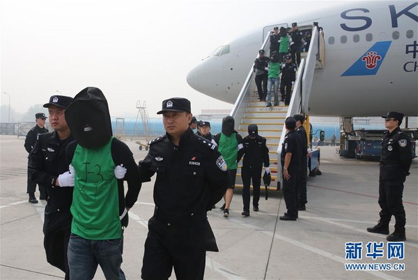 ▲因在肯亞涉及電信詐騙罪遭到羈押的台灣人，昨被中方強行帶走，根據《新華社》最新的照片顯示，這批人員已經飛抵北京機場。 根據《新華社》報導，9日遭到肯亞遣返中國的共有10人，今天飛抵北京的則共67人，其中包括45名台灣人和32名中國籍嫌犯。 從發布的照片中可以看到，嫌疑人均被套上黑色頭套未露臉，而飛機座位安排上，每位嫌犯左、右各有一名警員「護送」。 （圖／翻攝自新華社）