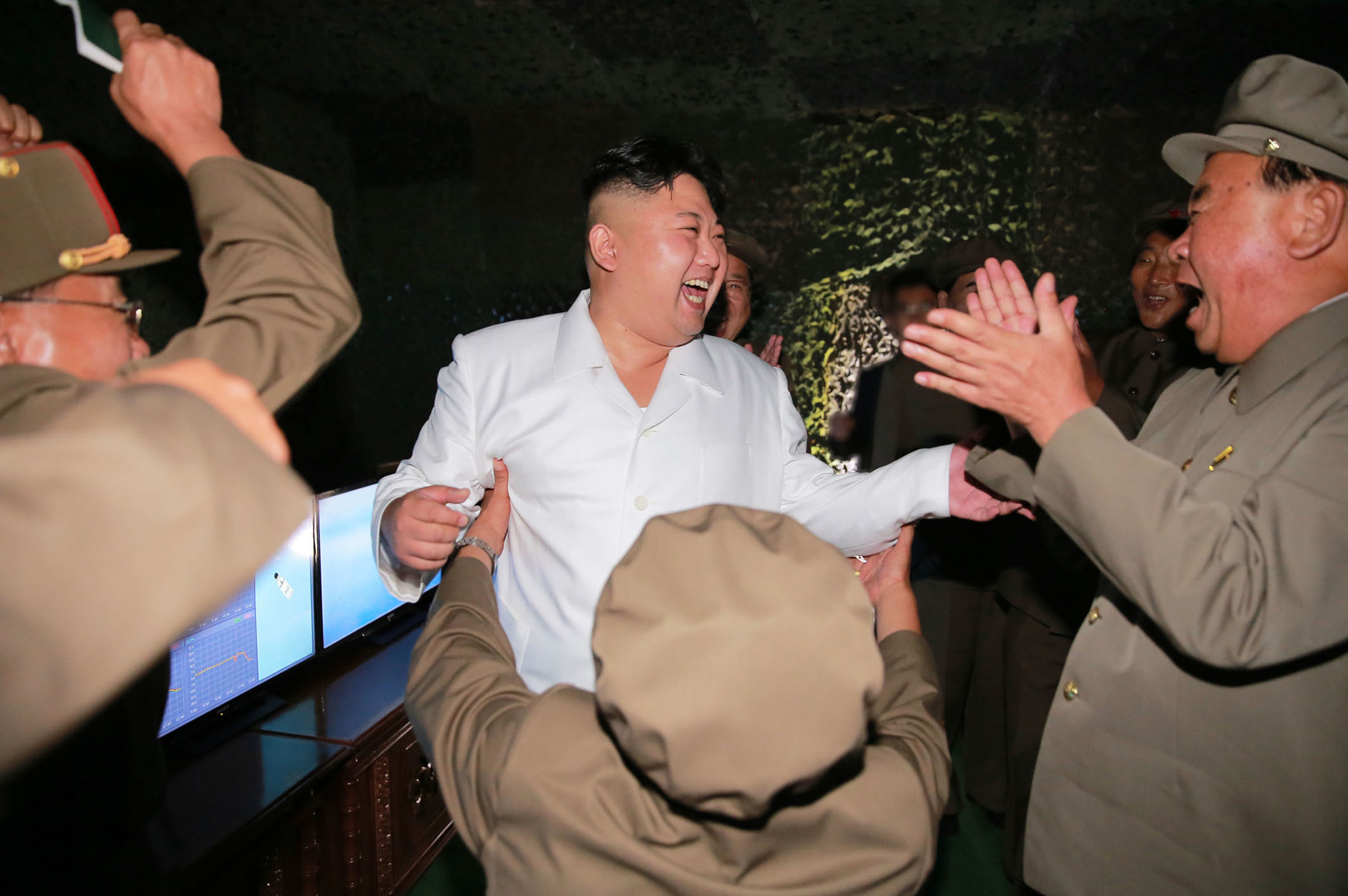 北韓飛彈試射成功後，金正恩開懷大笑，和官員們互相擁抱。（圖／達志影像／美聯社）