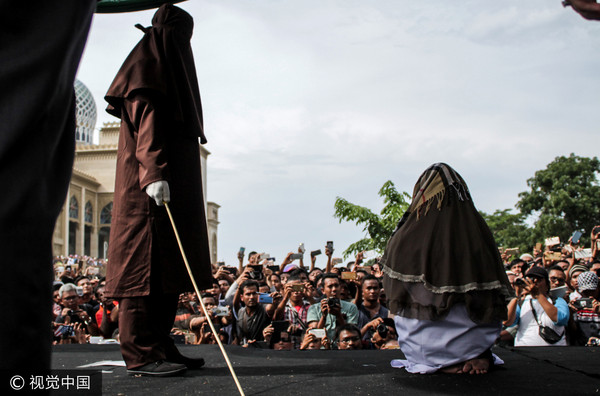 ▲▼印尼亞齊特區（Aceh）一名女子與男子聊天，犯下通姦罪鞭刑100下。（圖／CFP）