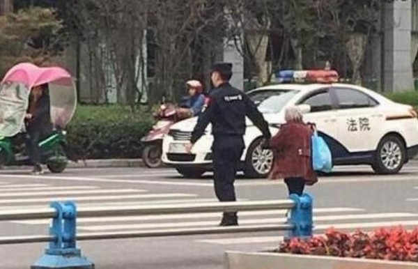 ▲▼四川22歲警察牽80歲老婆婆過街，上萬人讚「最暖牽手」。（圖／翻攝自中國新聞網）