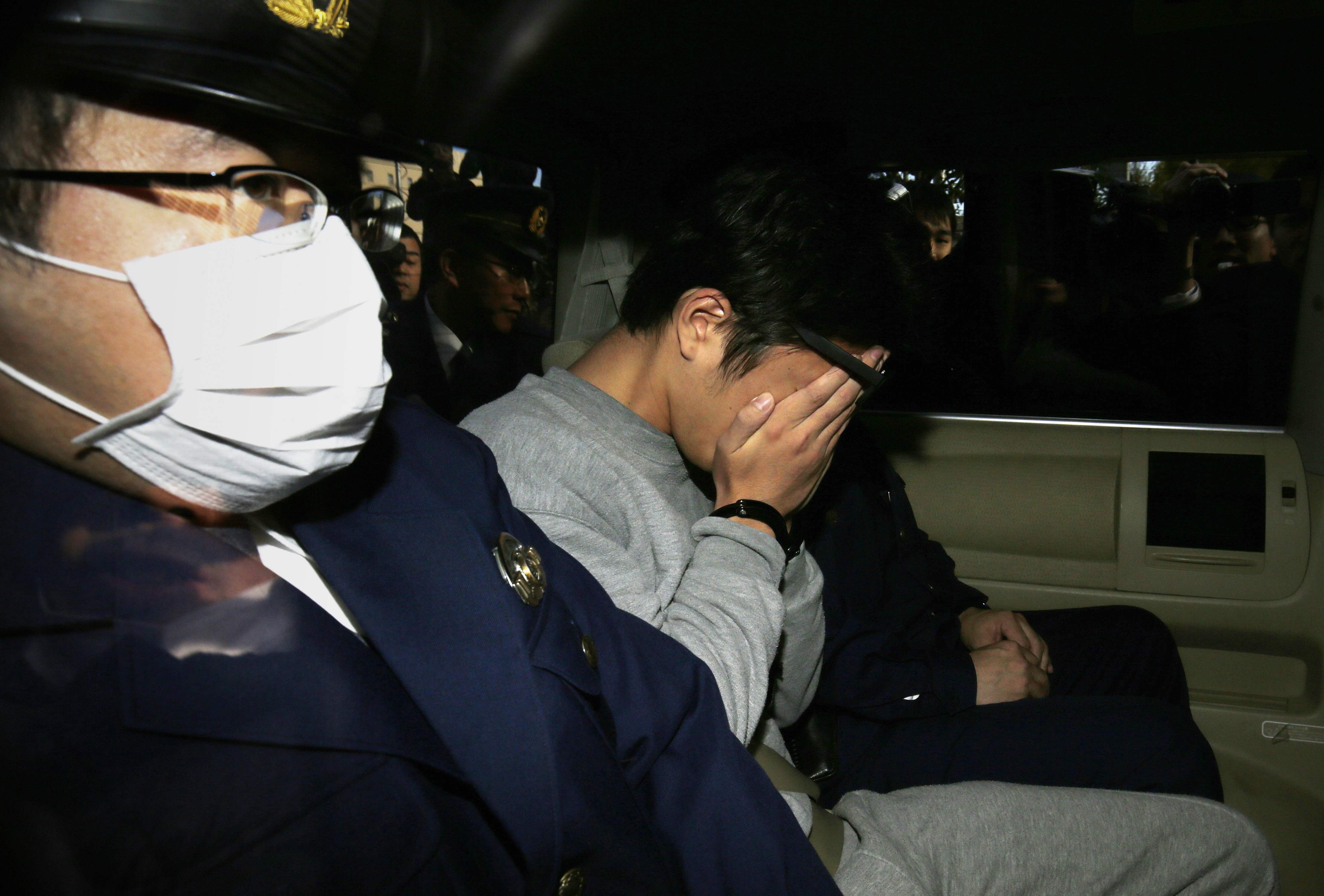 日本神奈川县27岁男子白石隆浩涉嫌杀害9人,他被移送时低头遮脸.