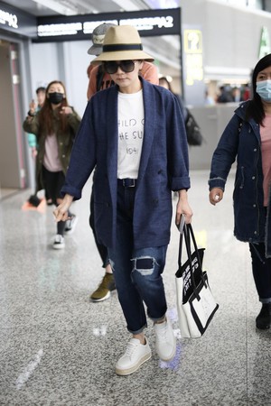 Ella：一向走帥氣路線的Ella，結束上海的節目錄影後抵達機場，她運用簡潔的西裝外套搭配看似兩個，實為一體的法文標語購物袋，品味獨特。（東方IC）
