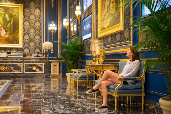 坐在富麗堂皇的廳堂，巴黎女人露出心動微笑。