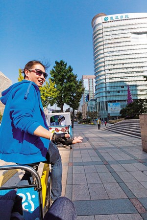 阿弟三輪車服務人員臉微紅地賣力踩著踏板，同時導覽，相當敬業。