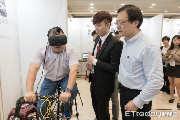 圖一：世新大學董事長周成虎(左一體驗者)體驗世新資管系學生開發之VR單車遊戲。（圖／世新大學提供）