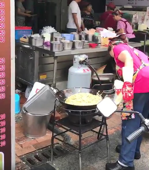 台中市繼光街一間60年老字號的早餐店竟戴的清洗用塑膠手套，翻攪熱鍋裡的炒麵，全程都被消費者拍下。（圖／翻攝「爆廢公社」）