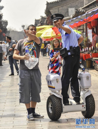 ▲▼駕駛平衡車的警察在平遙古城內幫旅客解決問題。（圖／翻攝自新華網）