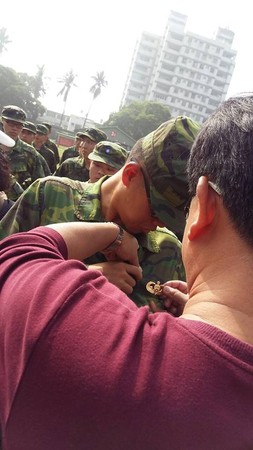 陸軍航特部26歲傘兵秦良丰父親幫兒子別上傘徽。（圖／翻攝秦良丰父親臉書）