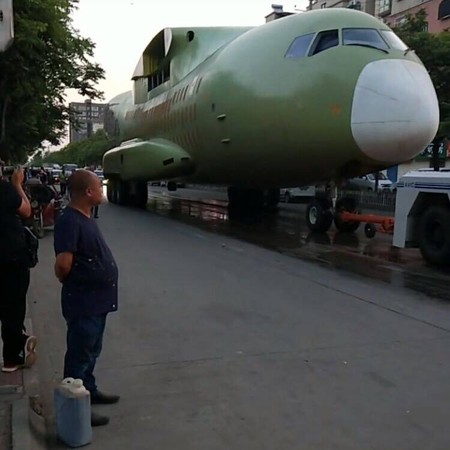 一架黃綠塗裝機體，在拖車牽引下於閻良街頭緩慢移動，外界認為這是正在研製的運-30中型運輸機，也有一說認為其為運-20靜力試驗機。（圖／翻攝自「中共西安市閻良區委宣傳部」微博）