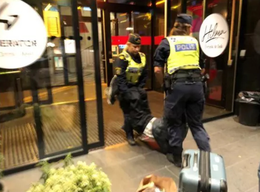 ▲▼陸客遭瑞典警方抓住四肢拖出旅館。（圖／翻攝自央視新聞／同下）