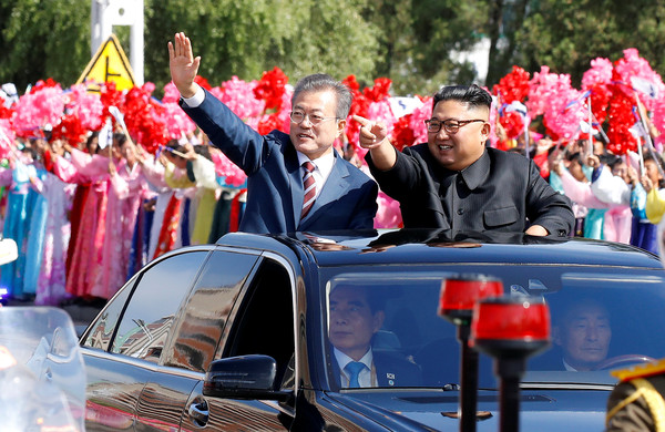 ▲文在寅(左)、金正恩坐敞篷車巡遊平壤街頭。北韓動員10萬人夾道歡迎。(圖／路透）