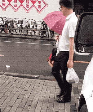 ▲中國上海下雨天路上有一名女兒要母親蹲下來幫她擦腳。（圖／翻攝自微博）