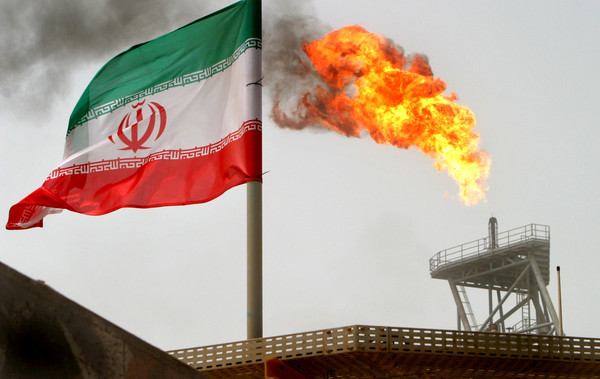 ▲▼伊朗石油田噴發的氣體火炬旁飄揚著國旗。（圖／路透）