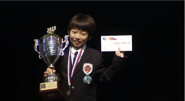 ▲11歲的福地啟介拿著冠軍獎盃在台上露出靦腆笑容。（圖／翻攝自YouTube／World Othello）