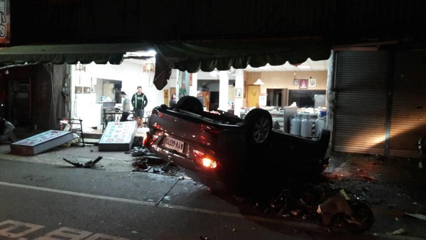 肇事的小轎車失控衝撞對向店家後180度翻覆，現場滿目瘡痍。（警方提供）