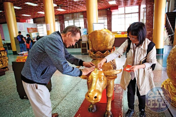 來到高雄關帝廟求財,一定要幫1樓財神殿前的金牛貼上金箔。