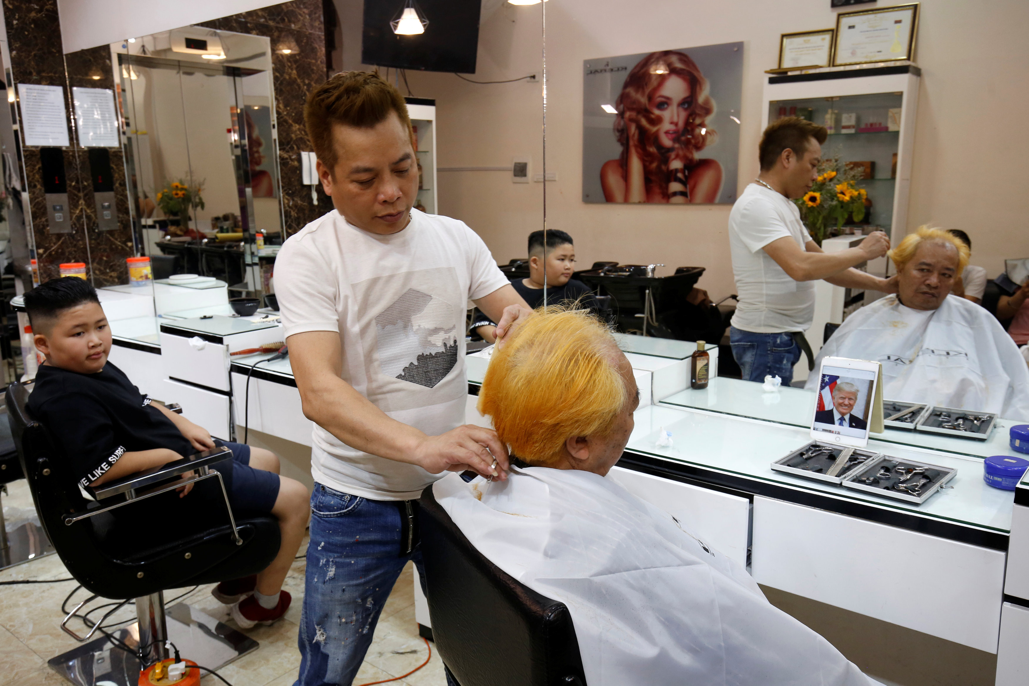 ▲▼越南河內的理髮業者推出免費服務，可以選擇剪成金正恩或川普的造型。（圖／路透）