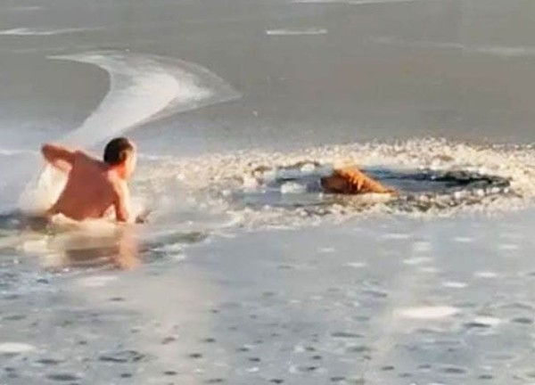 ▲尤里夫赤裸上身跳進酷寒的冰湖裡，搶救兩隻被困的狗狗。(圖／翻攝自YouTube)
