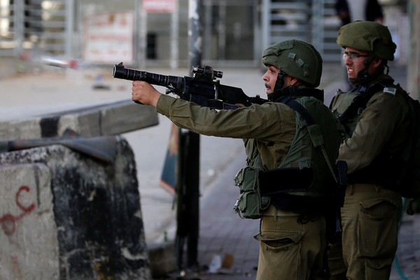 ▲▼以色列士兵在約旦河西岸佔領區，朝巴勒斯坦示威者發射催淚瓦斯。（圖／路透）