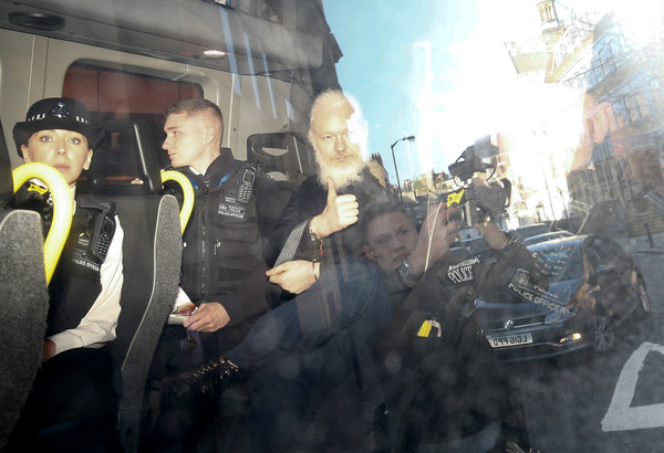 ▲▼維基解密創辦人亞桑傑（Julian Assange）在倫敦被逮捕，離開法庭後他在警車內比出大拇指手勢。（圖／路透）