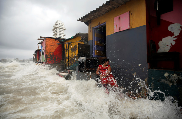 ▲印度孟買遭受超強季風雨襲擊。圖為住在海邊的一名女子，人和房子幾乎都已被怒濤淹。（圖／路透）