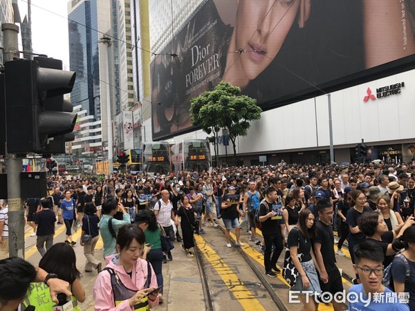 ▲香港818民陣集會人潮眾多，銅鑼灣站人群湧到馬路，車子幾乎難以移動。（圖／記者陳以昇攝）