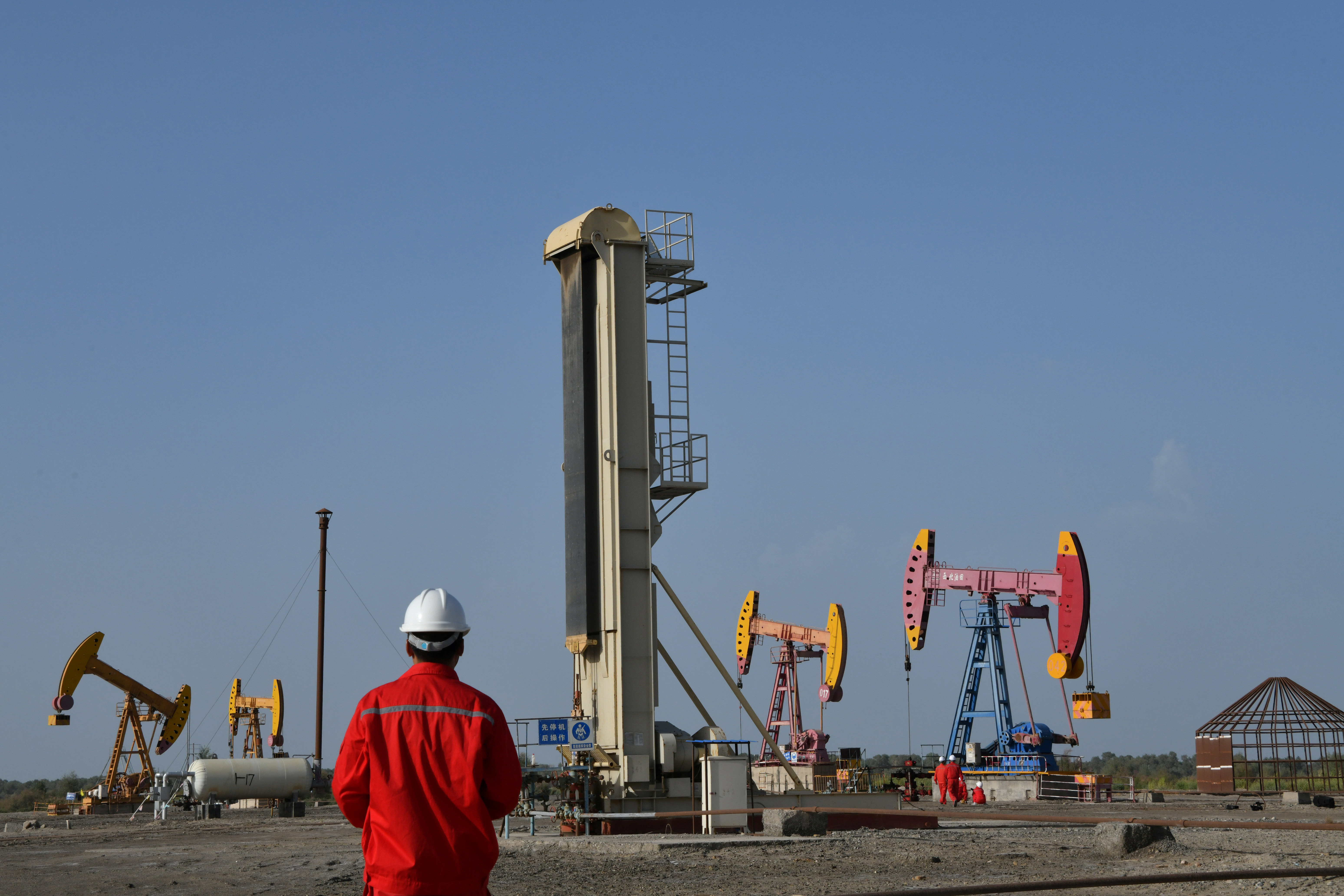 ▲▼中國石油天然氣集團（CNPC）新疆維吾爾自治區巴音郭楞蒙古自治州油田水泵附近的工人。（圖／路透）