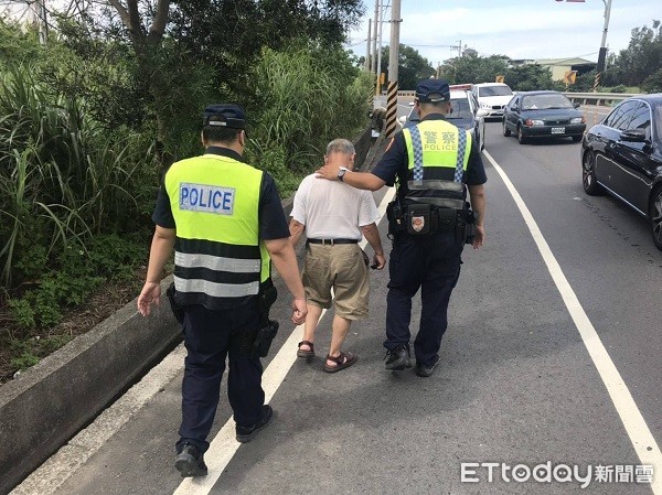 ▲警方即時救護因身體不適自撞路樹躺路旁的彭姓老翁。(圖/龍潭警分局提供)
