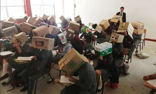 ▲墨西哥一位中學老師鐵西斯（右後方)為防止作弊，讓學(生們頭戴紙箱參加考試。(圖／翻攝自Mexico Daily News)