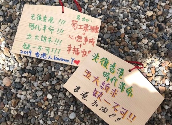 ▲大陸一名女網友在大阪一間神社參拜時，偷拔走支持香港的許願牌。（圖／翻攝自微博，下同）