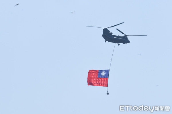 ▲108年國慶大典，運輸直升機吊掛國旗通過觀禮台。（圖／記者林敬旻攝）