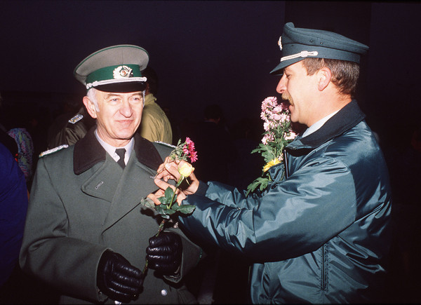 ▲▼柏林圍牆倒塌30周年。東、西德警察交換鮮花。（圖／達志影像／美聯社）