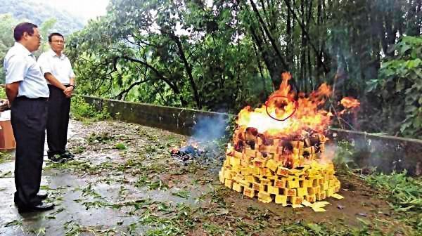 警方回現場祭拜亡靈，焚燒紙錢時，火焰中出現人臉（紅圈處）。（翻攝畫面）