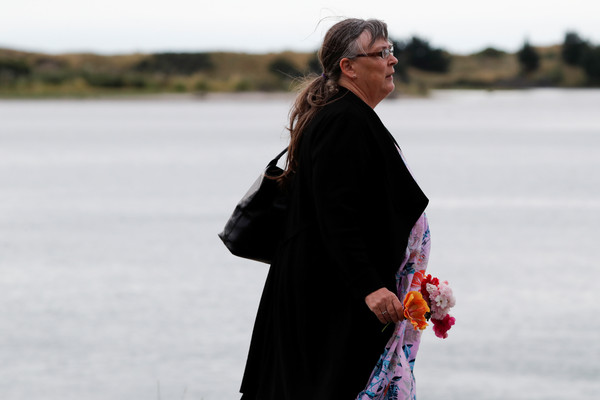 ▲▼紐西蘭懷特島（White Island）火山爆發，一名女子拿著花哀悼。（圖／路透）
