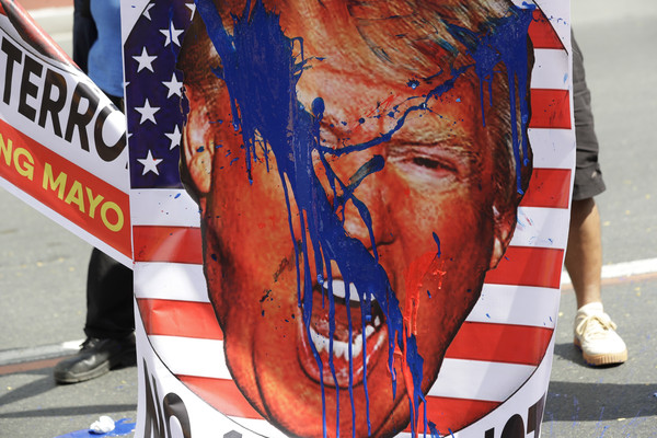 ▲▼美國總統川普（Donald Trump）的照片被示威者潑漆，以此抗議伊朗軍事將領蘇雷曼尼（Qasem Soleimani）之死。（圖／達志影像／美聯社）