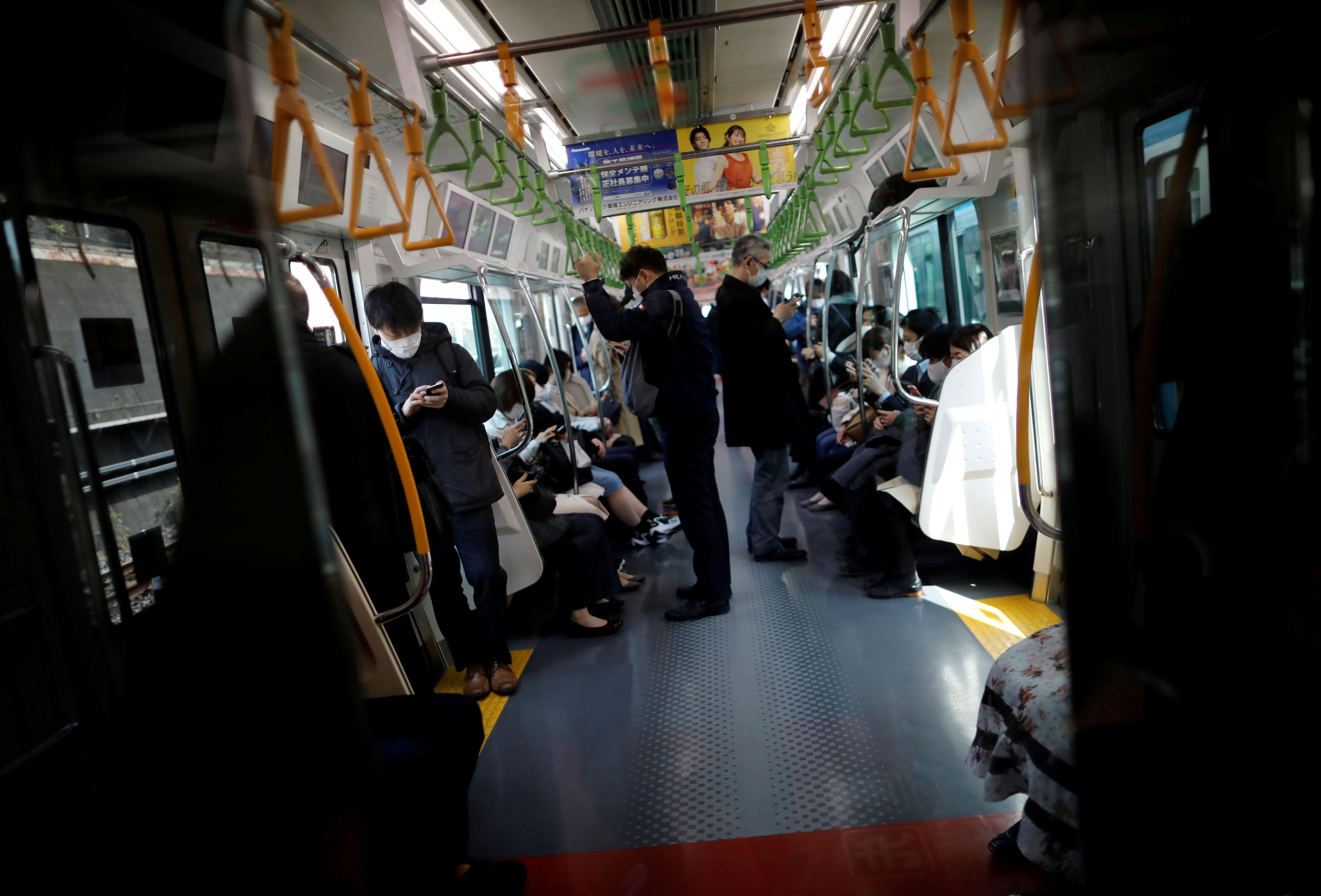 ▲▼日本進入緊急狀態後，乘客戴著口罩通勤。（圖／路透）