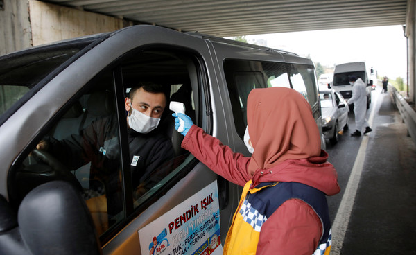 ▲▼土耳其決定關閉31個城市的所有車輛的邊界後，醫務人員檢查伊斯坦布爾附近高速公路上的駕駛員溫度，但不包括必需品的過境通道。（圖／路透）