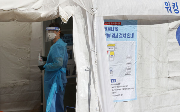 ▲▼南韓首爾一名醫療人員正在臨時診療所前針對新冠病毒進行測試。（圖／達志影像）