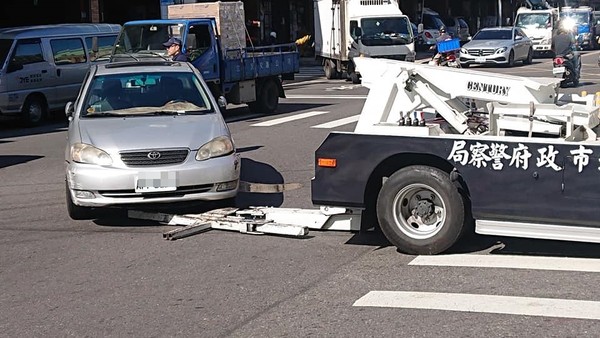 ▲▼拖吊車在轉彎時螃蟹夾上的轎車突然脫鉤，造成前車頭嚴重毀損。（圖／翻攝自爆料公社）