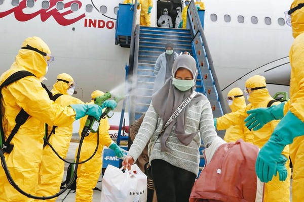 印尼疫情升溫，台灣目前暫停引進該國移工來台。圖為去年2月印尼人自中國武漢撤離返國的畫面。（達志影像）