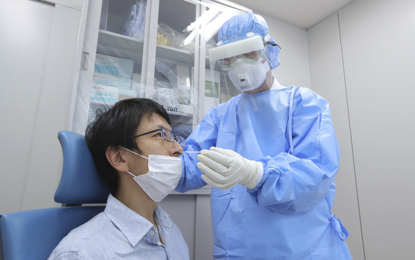 ▲東京的新冠疫情高燒不退。圖為一名男子在醫院內接受檢測。(圖／達志影像／美聯社)