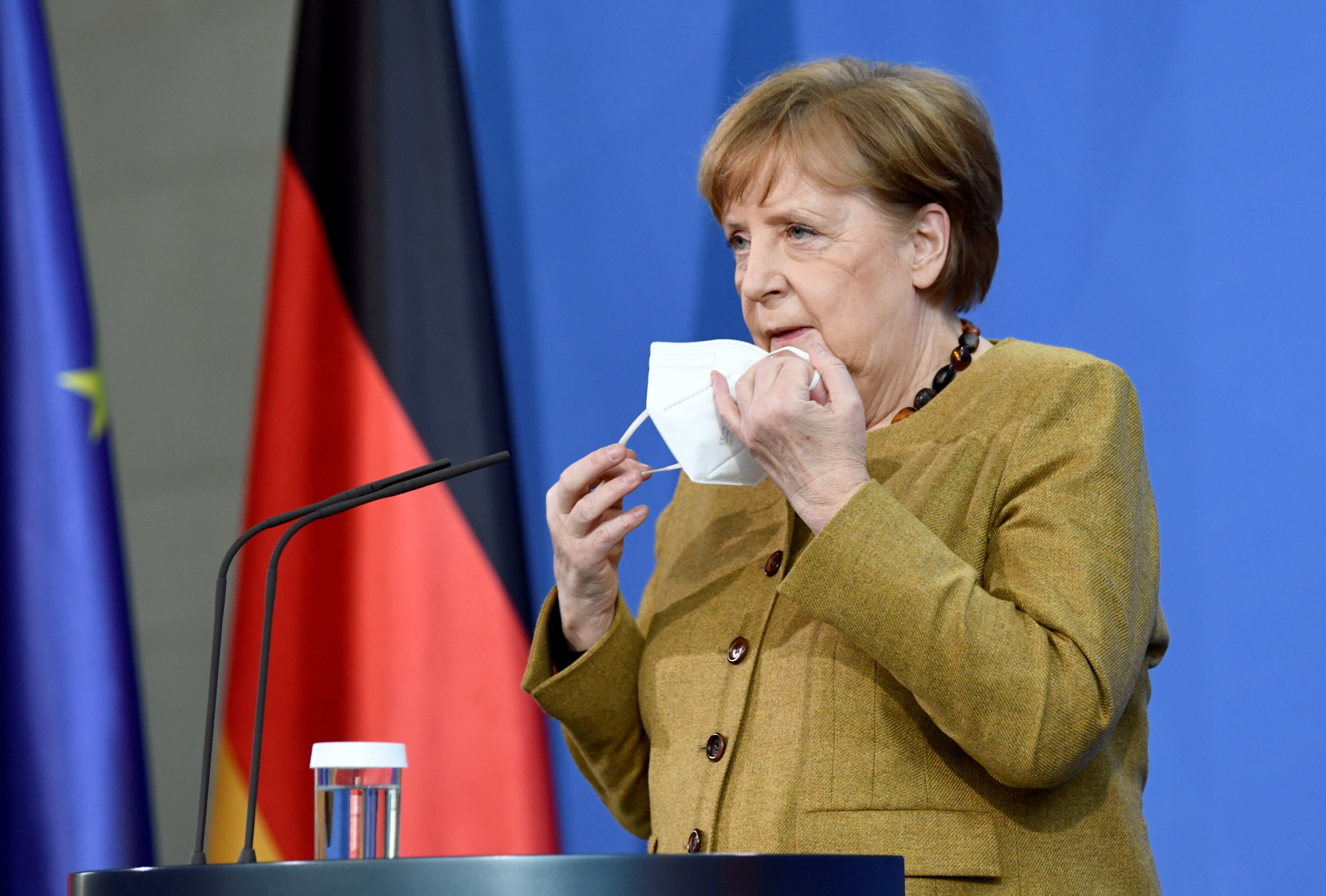 ▲▼德國總理梅克爾在演講完後，不小心把口罩忘在講台上。（圖／路透）