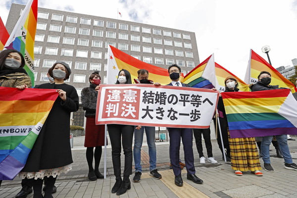 ▲▼  日本札幌地方法院17日一審判決日本政府不承認同性婚姻違憲，原告辯護律師與支持者在法院前舉出「婚姻平權跨出重大一步」布條。（圖／路透）