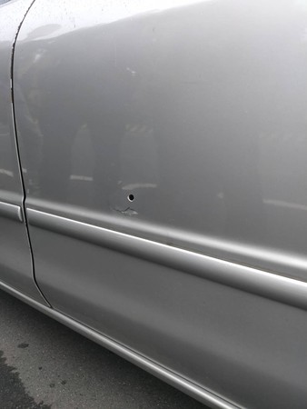 ▲▼銀色轎車遭警方開槍擊中。（圖／記者游宗樺翻攝）