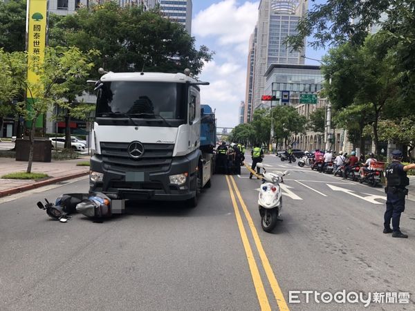 ▲▼台北市信義區松仁路松高路口發生一起死亡車禍，一輛砂石聯結車與一輛機車發生碰撞，機車騎士壓在車底，救護人員到場，發現騎士已明顯死亡。（圖／記者黃彥傑攝）