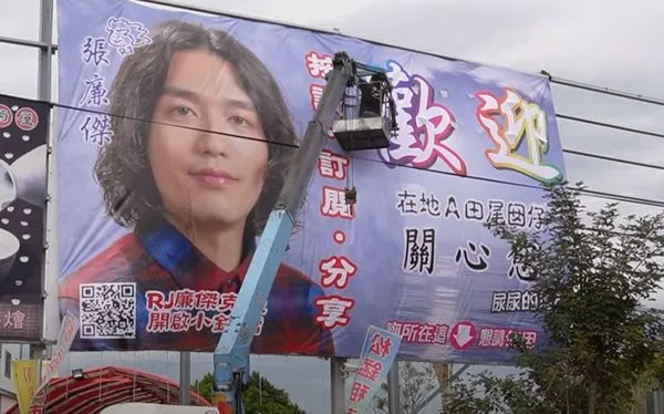 ▲▼在故鄉設置超大「頭像廣告」成走春景點 廉傑克曼笑:看我的臉找廁所。(圖/翻攝自YouTube)