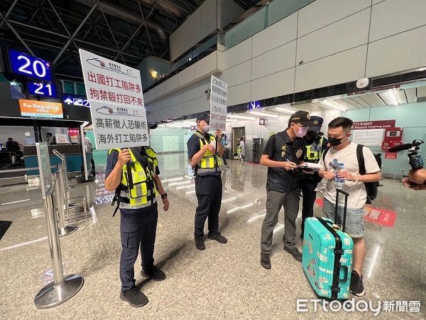 ▲航警局人員在機場櫃台舉牌勸阻國人飛柬埔寨。（圖／記者楊熾興翻攝）