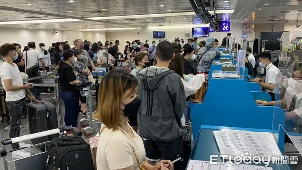 桃園機場東南亞的聯合報到櫃檯人潮爆滿,警方舉牌提醒民眾嚴防詐騙。 (圖/記者游宗樺攝)