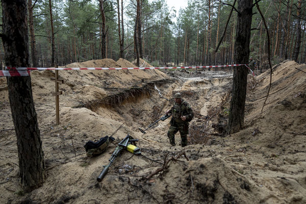 ▲▼烏克蘭軍人使用金屬探測器檢查伊久姆（Izium）一處萬人坑。（圖／達志影像／美聯社）